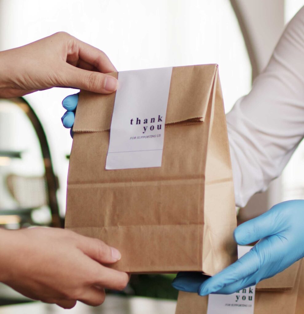 Hands handing off a bag of food with a seal on the top