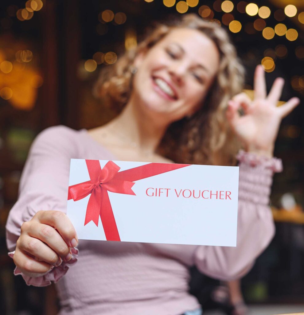 A woman holding a gift voucher with a red ribbon