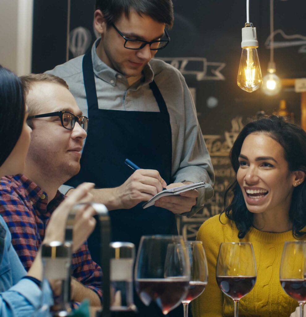 A waiter taking orders from a group of friends