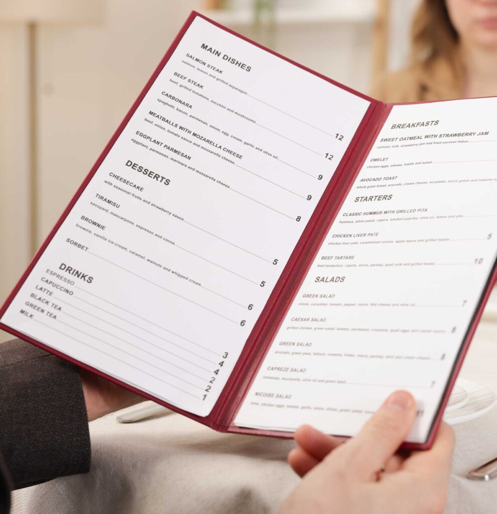 A customer holding open a restaurant menu while seated