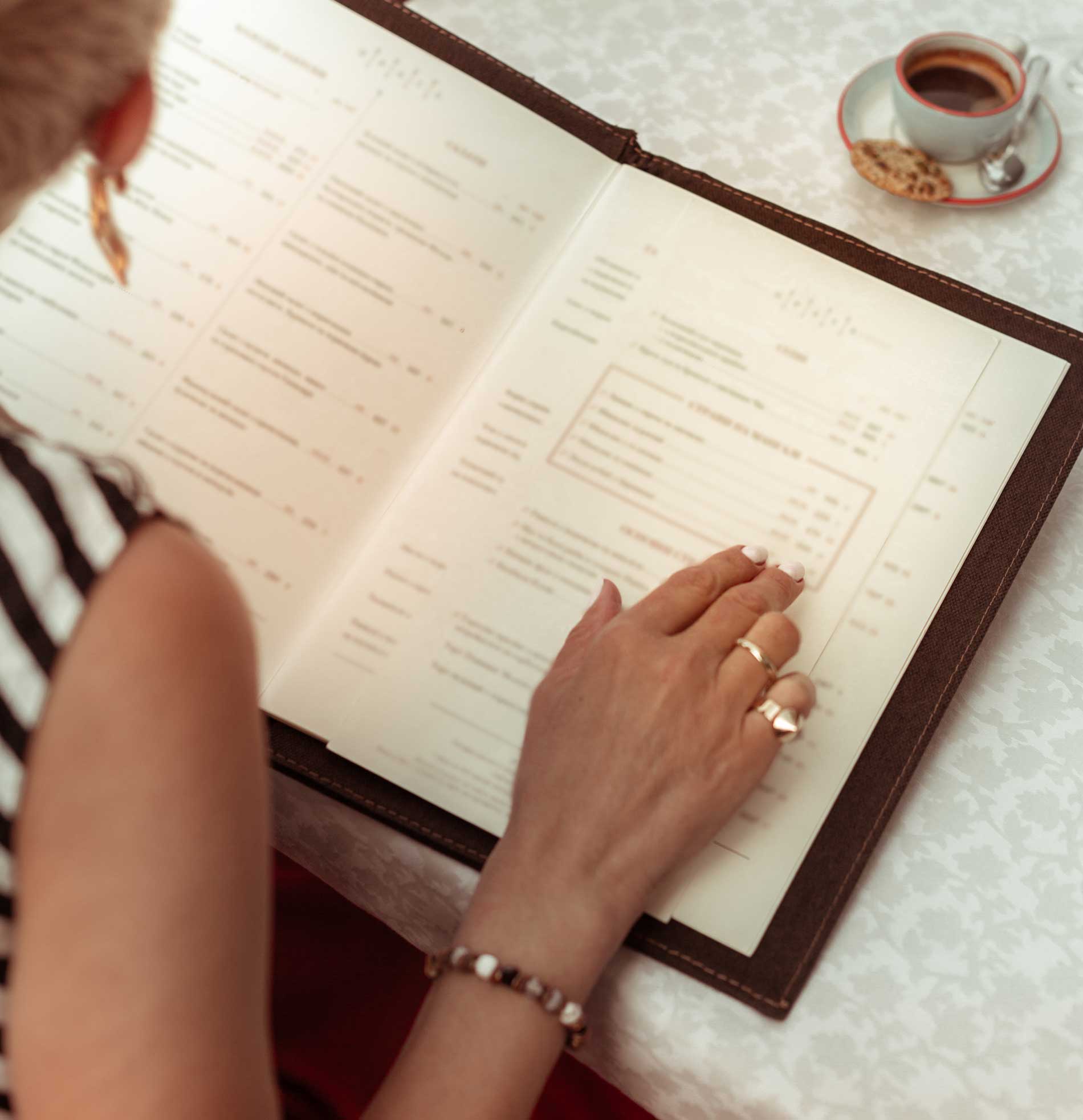 A woman checking a menu while seated in a restaurant