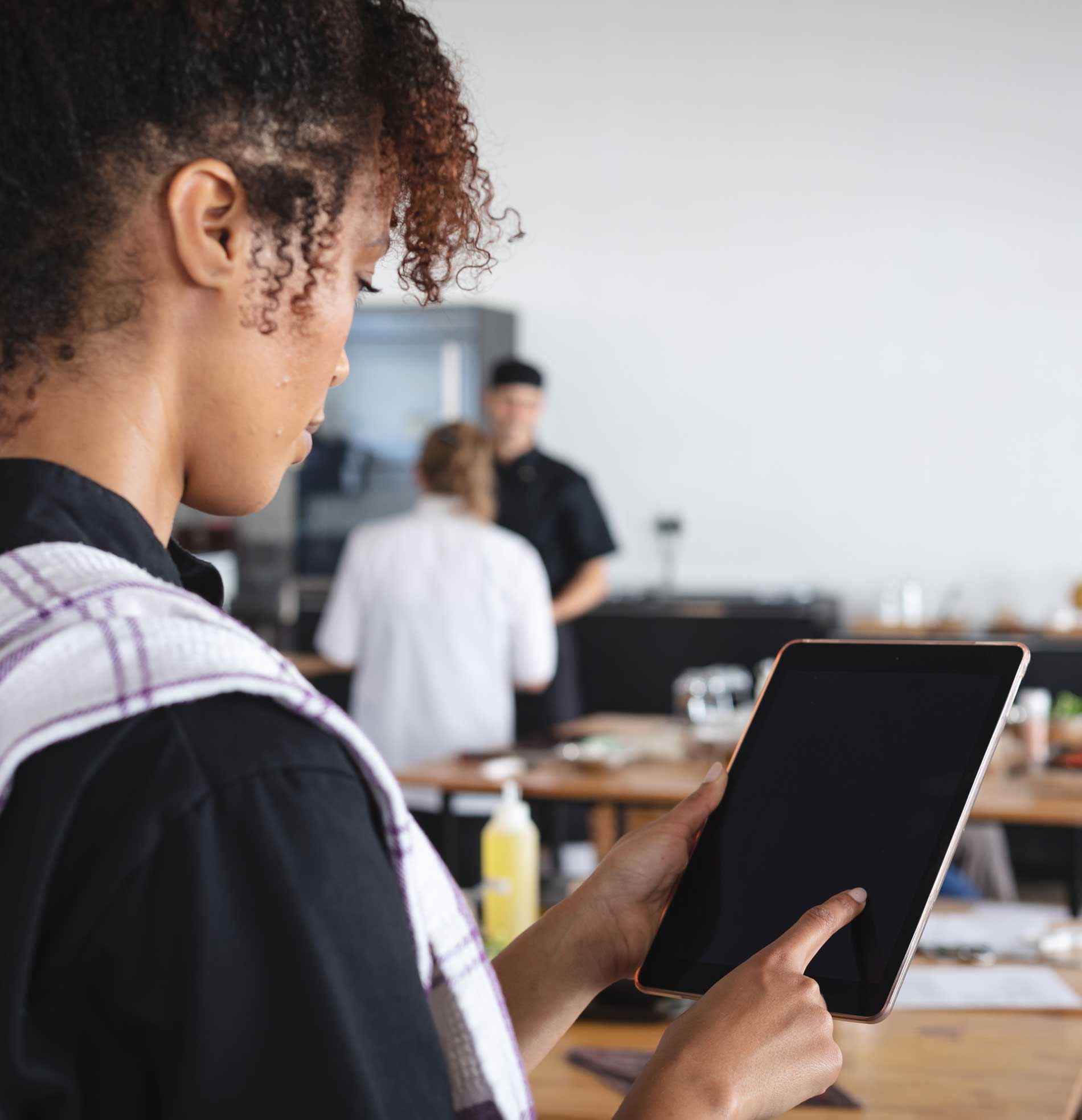 A woman touching the screen of a tablet