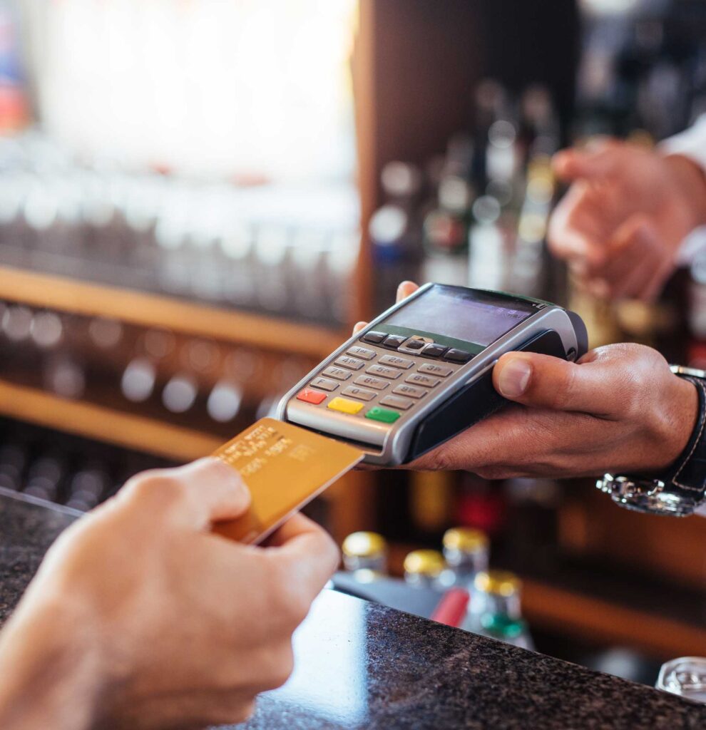 A customer putting their credit card into a handheld register device