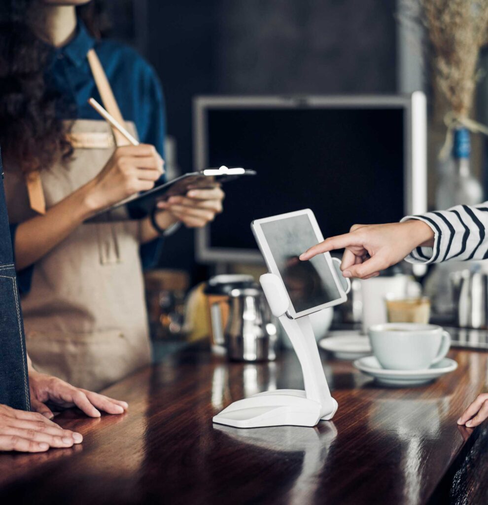 A customer inputting info on a touchpad at a coffee counter