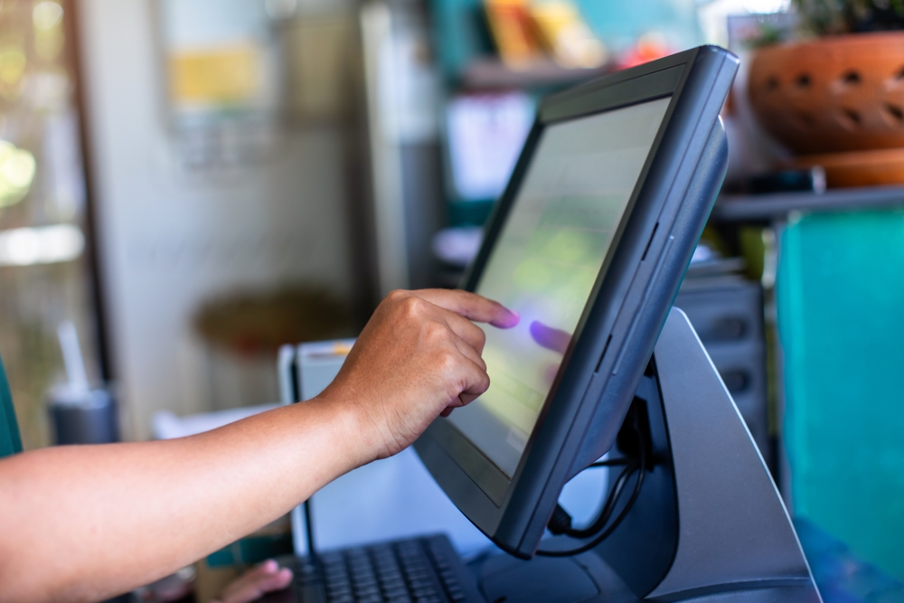 An employee typing something out on a touchscreen